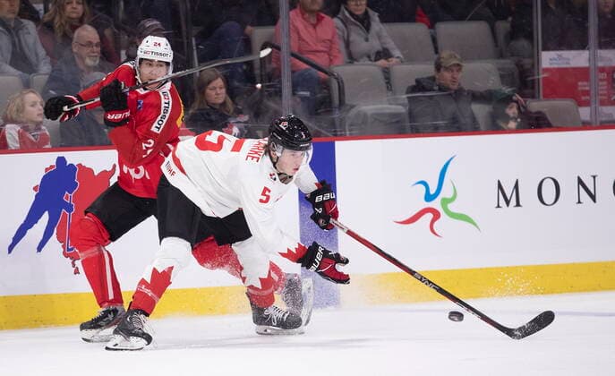 December 19, 2022, Moncton, NB, Canada: Switzerland s Liekit Reichle tries to get around Canada s Brandt Clarke during first period IIHF World Junior Hockey Championship pre-tournament hockey action in Moncton, N.B., on Monday, Dec. 19, 2022. Canada News - December 19, 2022  - ZUMAc35_ 20221219_zaf_c35_062 Copyright: xRonxWardx