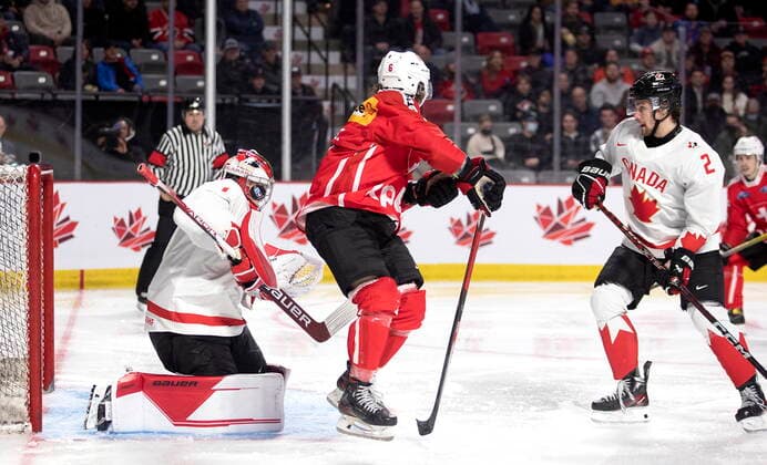 December 19, 2022, Moncton, NB, Canada: Canada s Thomas Milic stops the puck as Switzerland s Mischa Ramel screens him and Canada s Nolan Allan looks on during third period IIHF World Junior Hockey Championship pre-tournament hockey action in Moncton, N.B., on Monday, Dec. 19, 2022. Canada News - December 19, 2022  - ZUMAc35_ 20221219_zaf_c35_073 Copyright: xRonxWardx