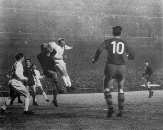 Real Madrid 3 , Barcelona 1 Madrid , Spain ; Di Stefano of Real Madrid , jumps up to head the ball with the Barcelona goalkeeper during their match in Madrid last night . The first goal for Real Madrid was scored in the 16th minute when Di Stefano headed the ball into the net from a pass by Puskas . Real Madrid beat Barcelona by three goals to one last night in the first of their semi - final play - offs for the European Cup . 21 April 1960 Spain  Copyright: xTopFotox 1336855