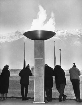 Olympic Flame Winter Olympics Although the Olympic flame symbolises the very essence of physical effort , these contestants idling beside it on the esplanade at Berg Isel seemed to have established a new Olympic category just resting . 6th February 1964 Austria  Copyright: xTopFotox UPI471136