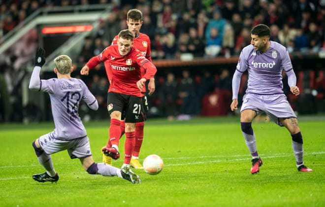 16 02 2023, GER, soccer, men, UEFA, soccer Europa League, play off, season 2022 2023, TSV Bayer 04 Leverkusen AS Monaco Florian Wirtz TSV Bayer 04 Leverkusen, center shoots in for 2 1 Caio Henrique AS Monaco, left and Guillermo Maripan AS Monaco, right Leverkusen BayArena Nordrhein Westfalen Germany