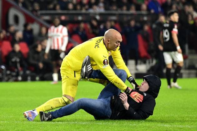 EINDHOVEN - PSV supporter assaults Sevilla FC goalkeeper Marko Dmitrovic during the UEFA Europa league play-off match between PSV Eindhoven and Sevilla FC at Phillips stadium on February 23, 2023 in Eindhoven, Netherlands. ANP OLAF KRAAK PSV Eindhoven v Sevilla FC: Knockout Round Play-Off Leg Two - UEFA Europa League 2022 2023 xVIxANPxSportx xxANPxIVx 463453204 originalFilename: 463453204.jpg