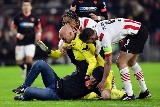 EINDHOVEN - PSV supporter assaults Sevilla FC goalkeeper Marko Dmitrovic during the UEFA Europa league play-off match between PSV Eindhoven and Sevilla FC at Phillips stadium on February 23, 2023 in Eindhoven, Netherlands. ANP OLAF KRAAK PSV Eindhoven v Sevilla FC: Knockout Round Play-Off Leg Two - UEFA Europa League 2022 2023 xVIxANPxSportx xxANPxIVx 463453228 originalFilename: 463453228.jpg