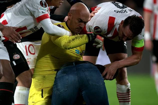 EINDHOVEN - A supporter fights with Sevilla FC goalkeeper Marko Dmitrovic during the UEFA Europa league play-off match between PSV Eindhoven and Sevilla FC at Phillips stadium on February 23, 2023 in Eindhoven, Netherlands. AP Dutch Height Jeroen Putmans PSV Eindhoven v Sevilla FC: Knockout Round Play-Off Leg Two - UEFA Europa League 2022 2023 xVIxANPxSportx xJeroenxPutmansxIVx 463453334 originalFilename: 463453334.jpg