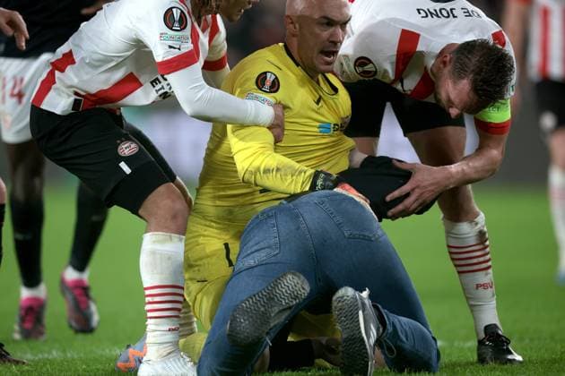 EINDHOVEN - A supporter fights with Sevilla FC goalkeeper Marko Dmitrovic during the UEFA Europa league play-off match between PSV Eindhoven and Sevilla FC at Phillips stadium on February 23, 2023 in Eindhoven, Netherlands. AP Dutch Height Jeroen Putmans PSV Eindhoven v Sevilla FC: Knockout Round Play-Off Leg Two - UEFA Europa League 2022 2023 xVIxANPxSportx xJeroenxPutmansxIVx 463453344 originalFilename: 463453344.jpg
