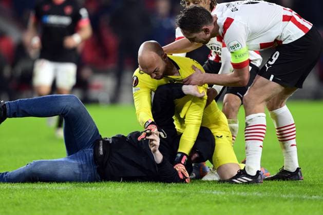 EINDHOVEN - PSV supporter assaults Sevilla FC goalkeeper Marko Dmitrovic during the UEFA Europa league play-off match between PSV Eindhoven and Sevilla FC at Phillips stadium on February 23, 2023 in Eindhoven, Netherlands. ANP OLAF KRAAK PSV Eindhoven v Sevilla FC: Knockout Round Play-Off Leg Two - UEFA Europa League 2022 2023 xVIxANPxSportx xxANPxIVx 463453266 originalFilename: 463453266.jpg