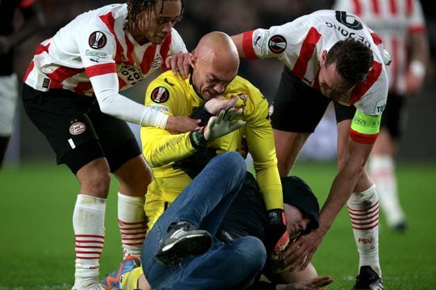 EINDHOVEN - A supporter fights with Sevilla FC goalkeeper Marko Dmitrovic during the UEFA Europa league play-off match between PSV Eindhoven and Sevilla FC at Phillips stadium on February 23, 2023 in Eindhoven, Netherlands. AP Dutch Height Jeroen Putmans PSV Eindhoven v Sevilla FC: Knockout Round Play-Off Leg Two - UEFA Europa League 2022 2023 xVIxANPxSportx xJeroenxPutmansxIVx 463453365 originalFilename: 463453365.jpg