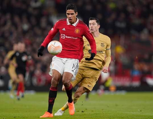 Manchester, England, 23rd February 2023. Raphael Varane of Manchester United, ManU under pressure from Robert Lewandowski of Barcelona during the UEFA Europa League match at Old Trafford, Manchester. Picture credit should read: Andrew Yates Sportimage EDITORIAL USE ONLY. No use with unauthorised audio, video, data, fixture lists, club league logos or live services. Online in-match use limited to 120 images, no video emulation. No use in betting, games or single club league player publications. SPI-2256-0026