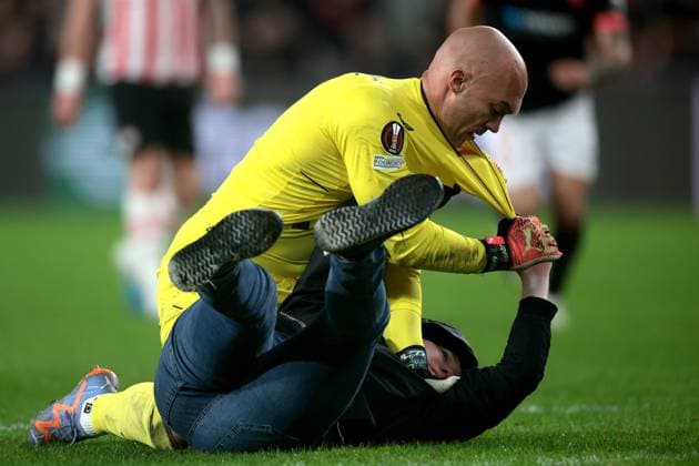 EINDHOVEN - A supporter fights with Sevilla FC goalkeeper Marko Dmitrovic during the UEFA Europa league play-off match between PSV Eindhoven and Sevilla FC at Phillips stadium on February 23, 2023 in Eindhoven, Netherlands. AP Dutch Height Jeroen Putmans PSV Eindhoven v Sevilla FC: Knockout Round Play-Off Leg Two - UEFA Europa League 2022 2023 xVIxANPxSportx xJeroenxPutmansxIVx 463454289 originalFilename: 463454289.jpg