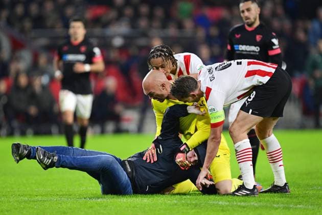 EINDHOVEN - A PSV supporter of PSV on the pitch with goalkeeper Marko Dmitrovic of Sevilla during the UEFA Europa league play-off match between PSV Eindhoven and Sevilla FC at Phillips stadium on February 23, 2023 in Eindhoven, Netherlands. ANP OLAF KRAAK PSV Eindhoven v Sevilla FC: Knockout Round Play-Off Leg Two - UEFA Europa League 2022 2023 xVIxANPxSportx xxANPxIVx 463455541 originalFilename: 463455541.jpg