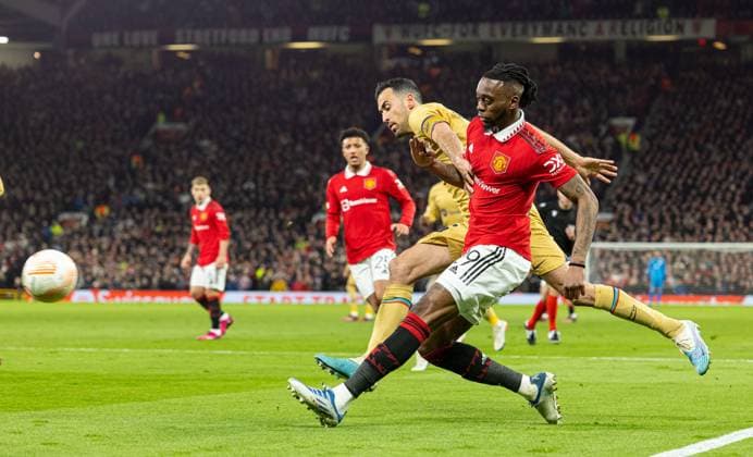 (230224) -- MANCHESTER, Feb. 24, 2023 -- Manchester United, ManU s Aaron Wan-Bissaka (R) passes the ball under pressure from Barcelona s Sergio Busquets during the UEFA Europa League play-off 2nd leg match between Manchester United and Barcelona in Manchester, Britain, Feb. 23, 2023. (SP)BRITAIN-MANCHESTER-FOOTBALL-UEFA EUROPA LEAGUE-MANCHESTER UNITED VS BARCELONA LixYing 