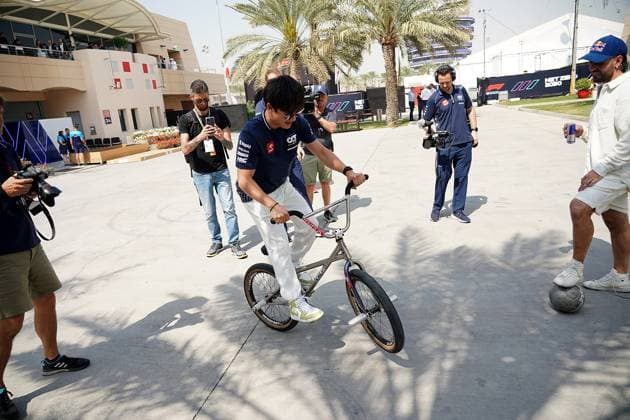 04 03 2023, Bahrain International Circuit, Sakhir, Formula 1 Gulf Air Bahrain Grand Prix 2023 ,in the picture Yuki Tsunoda JPN , Scuderia AlphaTauri with a bike Sakhir Bahrain International Circuit Bahrain  eu-images-506