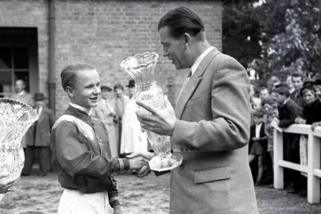 05.08.1956, Hoppegarten, Bezirk Strausberg, DDR - Jockey Alexander Mirus erhaelt nach dem Sieg im Preis von Angermuende den Ehrenpreis. Galopprennbahn Hoppegarten. (Siegerehrung, Sieg, Jockey, Mirus, historisch, schwarz-weiss) 560805A030HOPPEGARTEN.JPG *** 05 08 1956, Hoppegarten, district Strausberg, GDR jockey Alexander Mirus receives after the victory in the prize of Angermuende the honorary prize racecourse Hoppegarten award ceremony, victory, jockey, Mirus, historical, black white 560805A030HOPPEGARTEN JPG