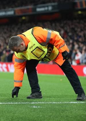 Arsenal gegen Sporting 16. März 2023, London UEFA EUROPA League Fußball Achtelfinale, 2. Spiel Arsenal gegen Sporting Clube de Portugal Ein Ordner hebt Trümmer vom Spielfeld auf, die von Sporting-Fans geworfen wurden Foto Charlotte Wilson Abseits London UK  Copyright: xCharlottexWilsonx xOffsidexOffside