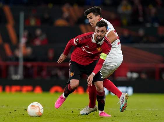 Manchester, England, 13th April 2023. Bruno Fernandes of Manchester United, ManU and Marcos Acuna of Sevilla during the UEFA Europa League match at Old Trafford, Manchester. Picture credit should read: Andrew Yates Sportimage EDITORIAL USE ONLY. No use with unauthorised audio, video, data, fixture lists, club league logos or live services. Online in-match use limited to 120 images, no video emulation. No use in betting, games or single club league player publications. SPI-2367-0032