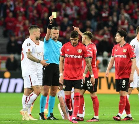 18 05 2023 Leverkusen football, mens, Europa League, semifinals, 2022 2023 season, Bayer 04 Leverkusen vs AS Roma referee Slavko Vinci shows Piero Hincapie Leverkusen, 3 the yellow card DFL regulations prohibit any use of photographs as image sequences and or quasi video BayArena NRW Germany