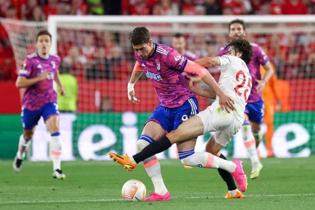 SEVILLE, SPAIN - MAY 18: Dusan Vlahovic of Juventus competes for the ball with Bryan Gil of Sevilla FC during the UEFA Europa League semi-final second leg match between Sevilla FC and Juventus at Estadio Ramon Sanchez Pizjuan on May 18, 2023 in Seville, Spain SPO 