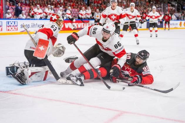 RIGA, LATVIA MAY 20 Janis Moser of Switzerland C stop Joe Veleno of Canada R in front of goalkeeper Leonardo Genoni of Switzerland L during the 2023 IIHF Ice Hockey World Championship Finland Latvia game between Canada Switzerland at Arena Riga on May 20, 2023 in Riga, Latvia Riga Arena Riga Latvia  Copyright: xJustPictures.ch JarixPestelaccix