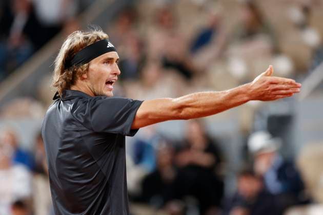 Alexander Zverev stretches out his arm and discusses a ball that was out of bounds Copyright: xJuergenxHasenkopfx