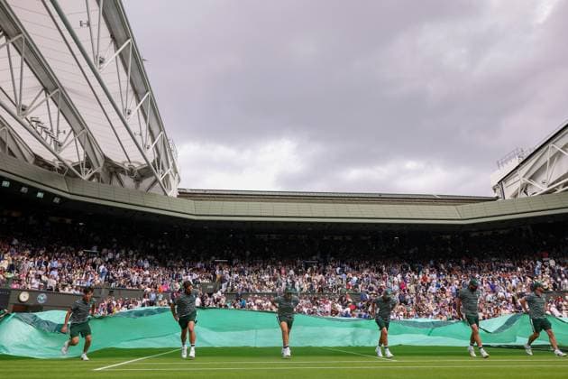 3rd July 2023; All England Lawn Tennis and Croquet Club, London, England: Wimbledon Tennis Tournament; Wimbledon grounds staff pull the covers over centre court as play is stopped due to rain  ActionPlus12526732 ShaunxBrooks