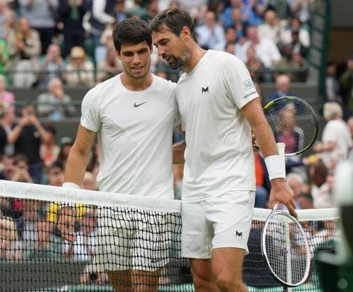 Tennis - 2023 Wimbledon Championships - Week One - Day Two - All England Lawn Tennis & Croquet Club, Wimbledon - Tuesday 4th July 2023 Carlos Alcaraz (ESP) v Jeremy Chardy (FRA) Carlos Alcaraz (ESP) at the net with Chardy after the match 