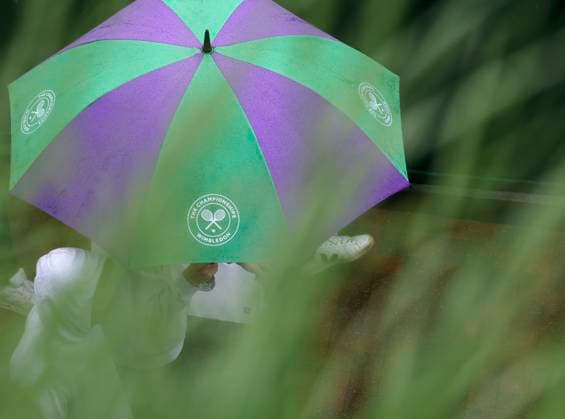 (230705) -- LONDON, July 5, 2023 -- People walk with an umbrella in the rain during the second day at Wimbledon tennis Championship in London, Britain, on July 4, 2023. Rain stopped play at Wimbledon for the second day. ) (SP)BRITAIN-LONDON-TENNIS-WIMBLEDON-DAY 2 HanxYan 
