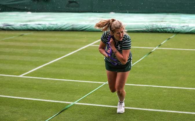 (230705) -- LONDON, July 5, 2023 -- A ground staff pulls the rain cover to protect the grass court at the beginning of the rain delay during the women s singles first round match between Zhang Shuai of China and Donna Vekic of Croatia at Wimbledon Tennis Championships in London, Britain, July 5, 2023. ) (SP)BRITAIN-LONDON-TENNIS-WIMBLEDON-DAY 3 HanxYan 