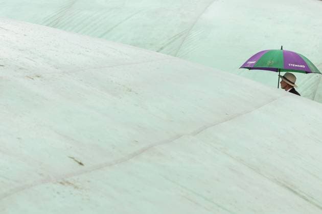 Wimbledon Tag drei 5. Juli 2023, Wimbledon Wimbledon Tennis Championships Tag drei ein Steward mit einem Regenschirm geht zwischen überdachten Plätzen Foto Charlotte Wilson Offside Wimbledon UK  Copyright: xCharlottexWilsonx xOffsidexOffside
