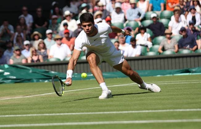 Spain s Carlos Alcaraz plays a forehand in his third round match against France s Alexandre Muller on day five of the 2023 Wimbledon championships in London on Friday, July 07, 2023.  LON2023070756 HUGOxPHILPOTT