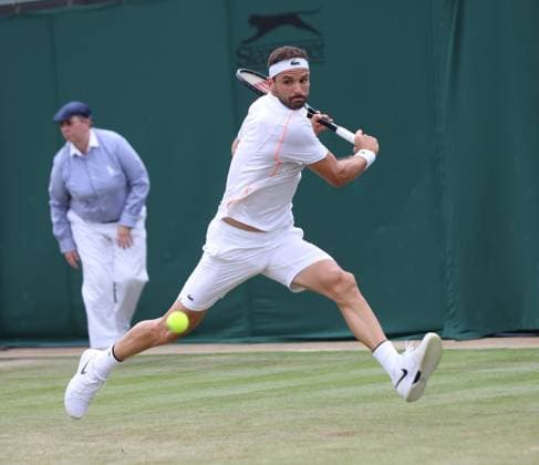 Bulgarian Gregor Dimitrov plays a backhand in his match against American Frances Tiafoe on day six of the 2023 Wimbledon championships in London on Saturday, July 08, 2023.  LON2023070858 HUGOxPHILPOTT
