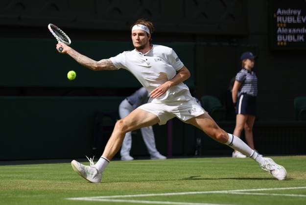 Kazakhstan s Alexander Bublik plays a forehand in his match against Russian Andrey Rublev on day seven of the 2023 Wimbledon championships in London on Sunday, July 9, 2023.  LON2023070936 HUGOxPHILPOTT
