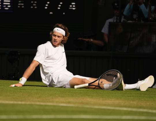 Tennis - 2023 Wimbledon Championships - Week One - Day Seven - All England lawn Tennis & Racquet Club, Wimbledon - Sunday 9th Mens singles - Andrey Rublev v Alexander Bublik (KAZ) Andrey Rublev scores a winning point as he falls over on the grass 