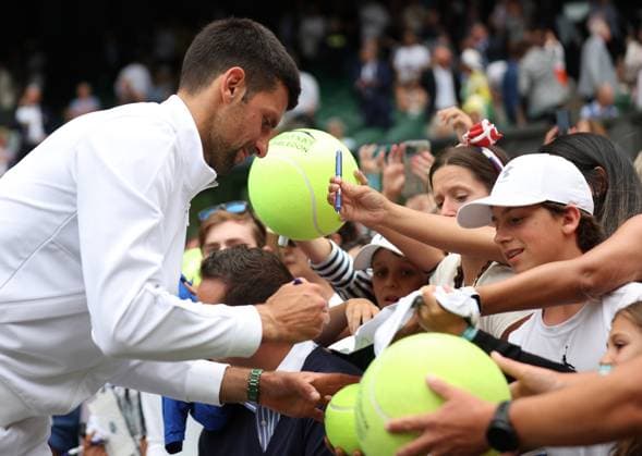Serbian Novak Djokovic signs autographs after his victory against Poland s Herbert Hurkacz on day eight of the 2023 Wimbledon championships in London on Monday, July 10, 2023.  LON2023071071 HUGOxPHILPOTT