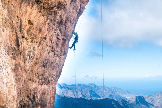 Archivbilder der Woche SPORT KW28 Rock climber climbing up overhanging cliff Rock climber climbing up overhanging cliff with Canary Island mountain range and sea on background (License=RF) 13163244 Copyright: xZoonar.com PavloxVakhrushevx 13163244