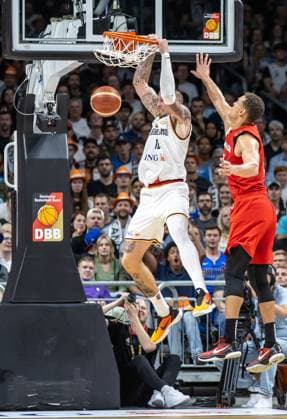 Basketball Laenderspiel, Germany Canada, Mercedes Benz Arena Germanys Daniel Theis puts the ball in the basket and hangs on to it Basketball Laenderspiel Germany Canada