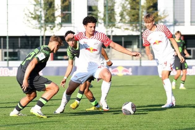 Soccer A Junioren Bundesliga Nord Nordost, Saison 2023 2024, 3 Spieltag, RasenBallsport Leipzig U19 vs VfL Wolfsburg U19 23 08 2023 Duel for the ball between Aris Bayindir Central midfield RB Leipzig U19, Rueckennummer 17 center and Kevin Lebersorger Right defender Wolfsburg U19, back number 27 left and Jonathan Vonheim Norbye center back RB Leipzig U19, back number 4 right during the match RBL U19 vs Wolfsburg U19 23 08 2023 Leipzig Saxony Germany RB Trainingszentrum am Cottaweg, Rasenplatz 1