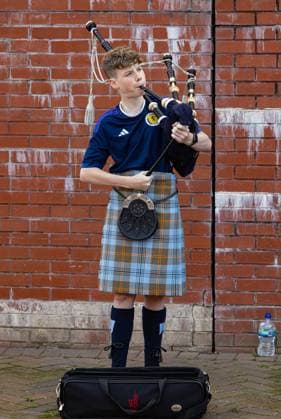 (230913) -- GLASGOW, Sept. 13, 2023 -- A young Scotland supporter plays the bagpipes before a friendly match between Scotland and England in Glasgow, Britain, on Sept. 12, 2023. (SP)BRITAIN-GLASGOW-FOOTBALL-FRIENDLY MATCH-SCOTLAND VS ENGLAND str 