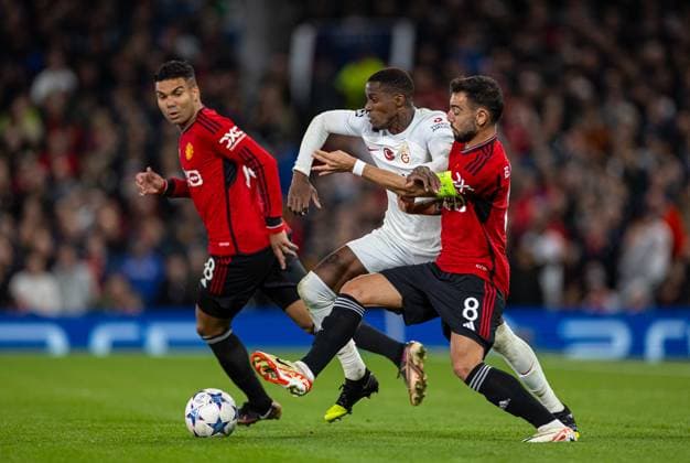 Football - UEFA Champions League - Group A - Manchester United, ManU FC v Galatasaray S.K. MANCHESTER, ENGLAND - Tuesday, October 3, 2023: Galatasaray s Wilfried Zaha is challenged by Manchester United s captain Bruno Fernandes during the UEFA Champions League Group A match between Manchester United FC and Galatasaray S.K. at Old Trafford. MANCHESTER Old Trafford GREATER MANCHESTER ENGLAND  Copyright: xDavidxRawcliffex P2023-10-03-Man_Utd_Galatasaray-55