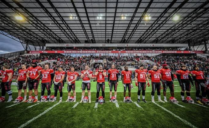 <p>Footballspieler singen die Nationalhymne am Samstag, den 14. Oktober 2023. Endspiel um die Deutsche Meisterschaft im American Football im Stadion an der Hafenstraße. Es spielen die Potsdam Royals gegen Schwäbisch Hall Unicorns. Ein buntes Rahmenprogramm findet vor dem Spiel am Stadion statt. Deutschland NRW Essen Copyright: KerstinxKokoska
