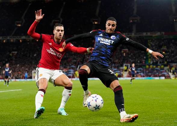 Manchester, England, 24th October 2023. Diogo Dalot of Manchester United, ManU tussles with Elias Achouri of FC Copenhagen during the UEFA Champions League match at Old Trafford, Manchester. Picture credit should read: Andrew Yates Sportimage EDITORIAL USE ONLY. No use with unauthorised audio, video, data, fixture lists, club league logos or live services. Online in-match use limited to 120 images, no video emulation. No use in betting, games or single club league player publications. SPI-2672-0046