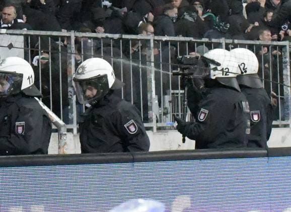 10 11 2023, xblx, football 2 Bundesliga, FC St Pauli Hannover 96 emspor, v l police with defense spray, tributes, spectators, stadium, fans, tribune, crowds, scarves, scarf, banner, posters, flag, flags, riots DFL DFB REGULATIONS PROHIBIT ANY USE OF PHOTOGRAPHS as IMAGE SEQUENCES and or QUASI VIDEO Hamburg