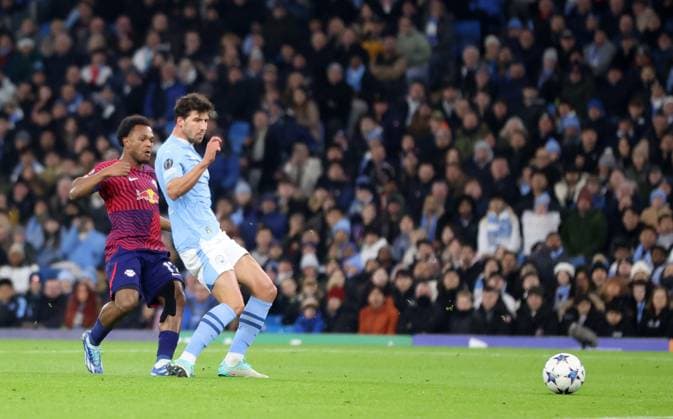 28th November 2023; Etihad Stadium, Manchester, England; Champions League Football, Group Stage, Manchester City versus RB Leipzig; Lois Openda of RB Leipzig holds off a challenge from Ruben Dias of Manchester City shoots past goalkeeper Stefan Ortega to give his side a 0-1 lead after 13 minutes  ActionPlus12580855 DavidxBlunsden