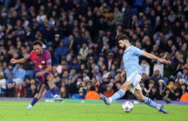 28th November 2023; Etihad Stadium, Manchester, England; Champions League Football, Group Stage, Manchester City versus RB Leipzig; Lois Openda of RB Leipzig shoots past Josko Gvardiol of Manchester City and goalkeeper Stefan Ortega to give his side a 0-2 lead after 33 minutes  ActionPlus12580865 DavidxBlunsden
