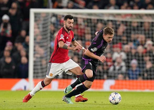 Manchester, England, 12th December 2023. Bruno Fernandes of Manchester United, ManU tussles with Joshua Kimmich of Bayern Munich during the UEFA Champions League match at Old Trafford, Manchester. Picture credit should read: Andrew Yates Sportimage EDITORIAL USE ONLY. No use with unauthorised audio, video, data, fixture lists, club league logos or live services. Online in-match use limited to 120 images, no video emulation. No use in betting, games or single club league player publications. SPI-2800-0013