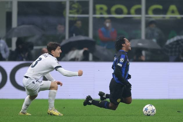 Sport Bilder des Tages Milan, Italy, 12th December 2023. Juan Cuadrado of FC Internazionale is upended by Aihen Munoz of Real Sociedad during the UEFA Champions League match at Giuseppe Meazza, Milan. Picture credit should read: Jonathan Moscrop Sportimage EDITORIAL USE ONLY. No use with unauthorised audio, video, data, fixture lists, club league logos or live services. Online in-match use limited to 120 images, no video emulation. No use in betting, games or single club league player publications. SPI-2786-0013