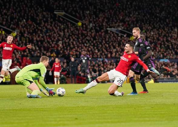 Manchester, England, 12th December 2023. Manuel Neuer of Bayern Munichcollects from a lunging Diogo Dalot of Manchester United, ManU during the UEFA Champions League match at Old Trafford, Manchester. Picture credit should read: Andrew Yates Sportimage EDITORIAL USE ONLY. No use with unauthorised audio, video, data, fixture lists, club league logos or live services. Online in-match use limited to 120 images, no video emulation. No use in betting, games or single club league player publications. SPI-2800-0045