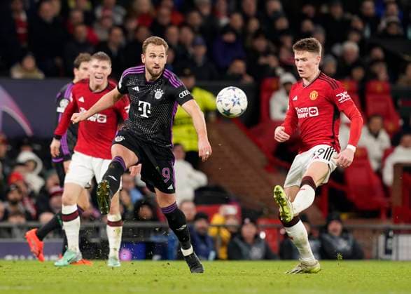 Manchester, England, 12th December 2023. Harry Kane of Bayern Munich distributes the ball despite Scott McTominay of Manchester Unitedduring the UEFA Champions League match at Old Trafford, Manchester. Picture credit should read: Andrew Yates Sportimage EDITORIAL USE ONLY. No use with unauthorised audio, video, data, fixture lists, club league logos or live services. Online in-match use limited to 120 images, no video emulation. No use in betting, games or single club league player publications. SPI-2800-0047