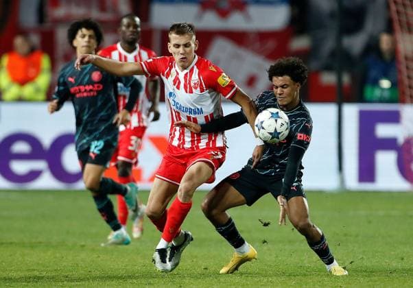 Oscar Bobb of Manchester City is challenged by Milos Degenek of Red Star Crvena zvezda v Manchester City, UEFA Champions League, Group G, Football, Rajko Mitic Stadium, Belgrade, Serbia - 13 Dec 2023 EDITORIAL USE ONLY No use with unauthorised audio, video, data, fixture lists, club league logos or live services. Online in-match use limited to 120 images, no video emulation. No use in betting, games or single club league player publications. Copyright: xNikolaxKrstic Shutterstockx 14254230dj