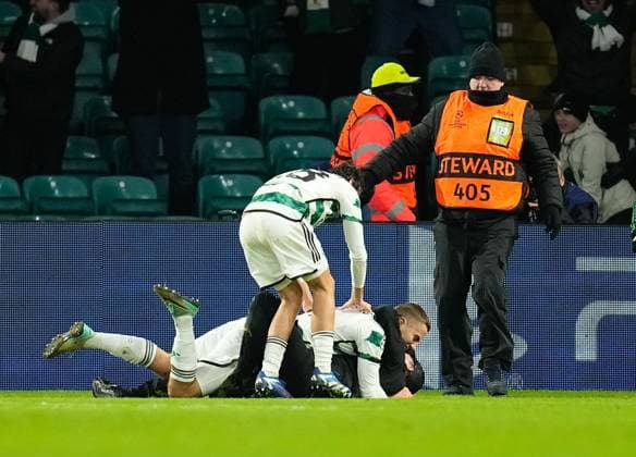 A Celtic fan on the pitch with Gustaf Lagerbielke of Celtic while Lagerbielke celebrates scoring to give Celtic a 2-1 lead. Celtic v Feyenoord, UEFA Champions League, Group E, Football, Celtic Park, Glasgow, UK - 13 Dec 2023 EDITORIAL USE ONLY No use with unauthorised audio, video, data, fixture lists, club league logos or live services. Online in-match use limited to 120 images, no video emulation. No use in betting, games or single club league player publications.  Copyright: xStuartxWallace Shutterstockx 14254242bd