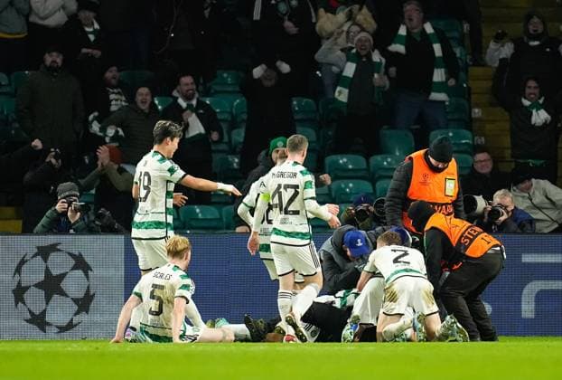 A Celtic fan on the pitch with Gustaf Lagerbielke of Celtic while Lagerbielke celebrates scoring to give Celtic a 2-1 lead. Celtic v Feyenoord, UEFA Champions League, Group E, Football, Celtic Park, Glasgow, UK - 13 Dec 2023 EDITORIAL USE ONLY No use with unauthorised audio, video, data, fixture lists, club league logos or live services. Online in-match use limited to 120 images, no video emulation. No use in betting, games or single club league player publications.  Copyright: xStuartxWallace Shutterstockx 14254242bf